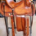 Rancher - 2 strand barbed wire w channels, stirrup lthrs out, 2 in bell stirrups, latigo wrap, straight-back, floral conchos