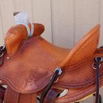 Bronc Buster-mule hide, straight-back, barbed wire w diamond border and full basket weave, hand-carved deer heads, floral conchos 2