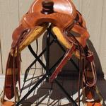 Rancher - basket weave border, 4 oak leaves, cheyenne roll, latigo, 3 in bell stirrups, saddlebags, floral conchos, stirrup lthrs out (2)